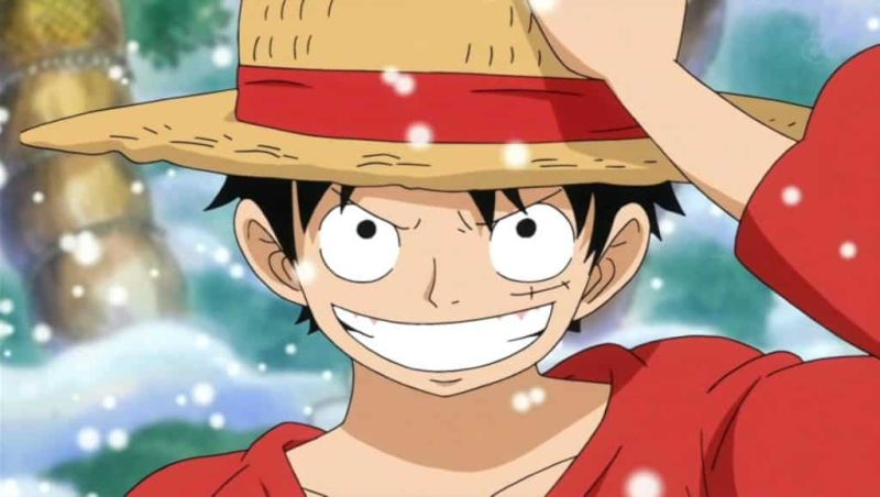 Luffy tenant son chapeau de paille en souriant